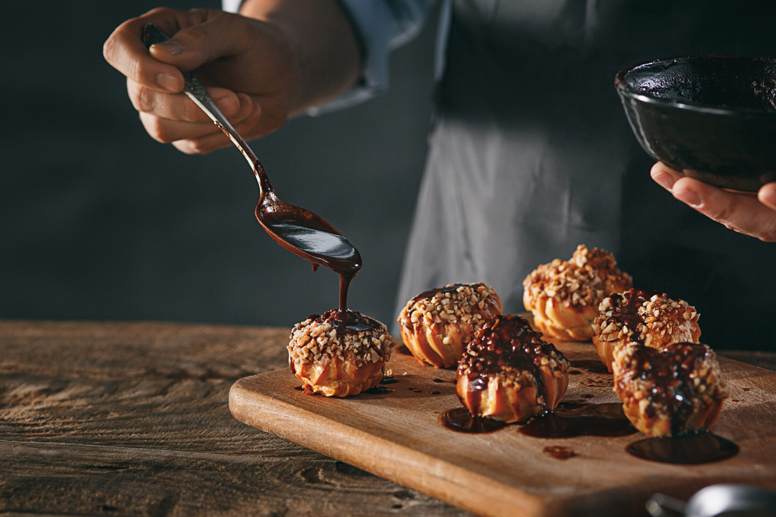 https://bakewithshivesh.com/wp-content/uploads/2022/07/decorating-delicious-homemade-eclairs-with-chocolate-peanuts-scaled.jpg